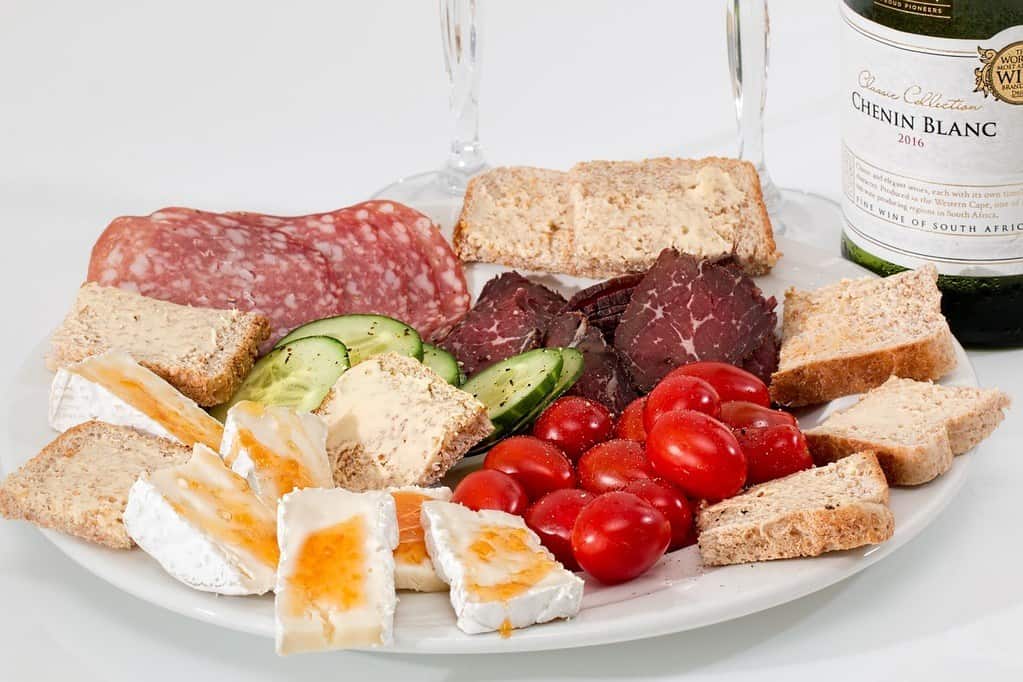 Platter with cheese, deli meat, tomatoes and bread for complete protein