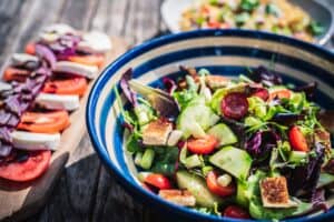 photo of 3 summer salads on a wooden table