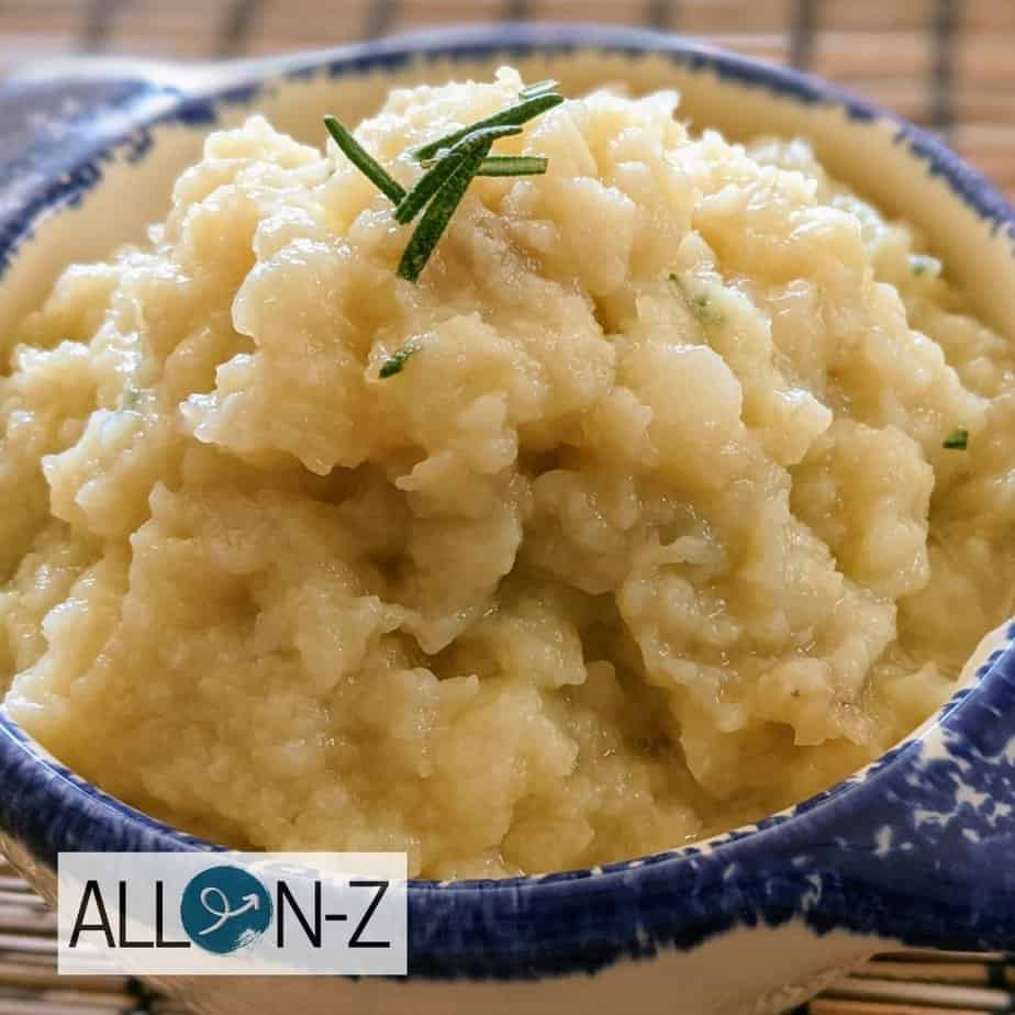 bowl of cauliflower mash with rosemary on top